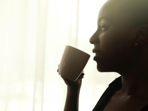 a woman is holding a cup of coffee at Novotel Constantine in Constantine