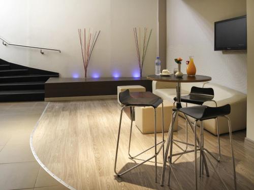 a living room with a table and chairs and a tv at Novotel Constantine in Constantine