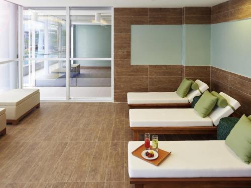 a living room with couches and chairs and a table at Novotel Rio de Janeiro Parque Olimpico in Rio de Janeiro