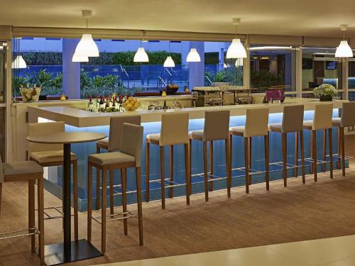 a kitchen with a bar with stools at Novotel Rio de Janeiro Parque Olimpico in Rio de Janeiro