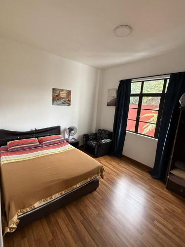 a bedroom with a bed and a window at Cameron Prima Villa Homestay in Tanah Rata