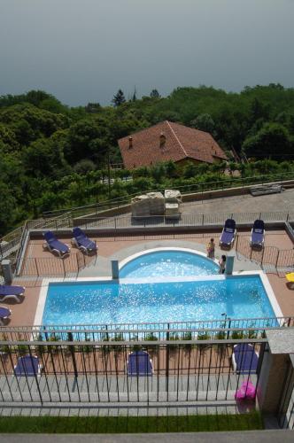 a large swimming pool with blue chairs at Residence Il Vigneto in Oggebbio