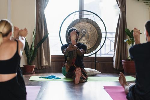 a woman taking a picture of a child doing yoga at Santoshi Guest House and Yoga Center in Pokhara