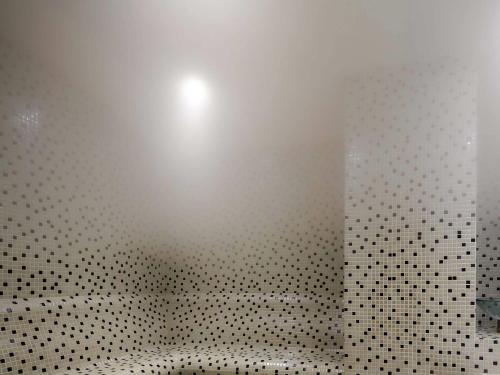 a bathroom with a black and white tiled wall at Novotel Konya in Konya