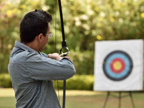 a man holding a arrow in front of a target at Novotel Imagicaa Khopoli in Khopoli