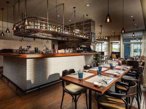 a restaurant with wooden tables and a bar at Pullman Dubai Jumeirah Lakes Towers in Dubai
