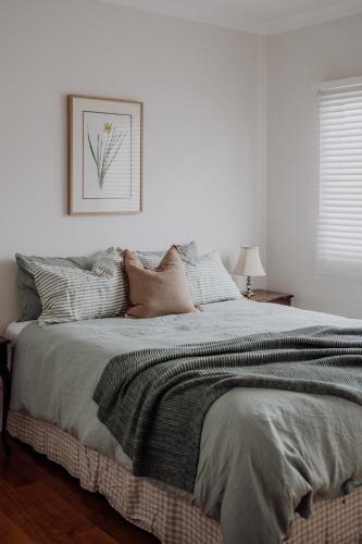 a white bedroom with a large bed with pillows at Lithgow Falls Marysville in Marysville