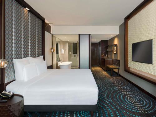 a hotel room with a large bed and a television at Pullman New Delhi Aerocity in New Delhi