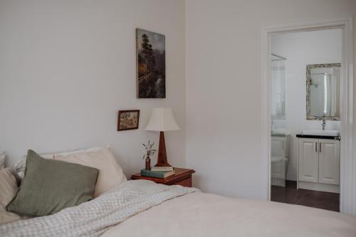 a bedroom with a bed and a table with a lamp at Lithgow Falls Marysville in Marysville