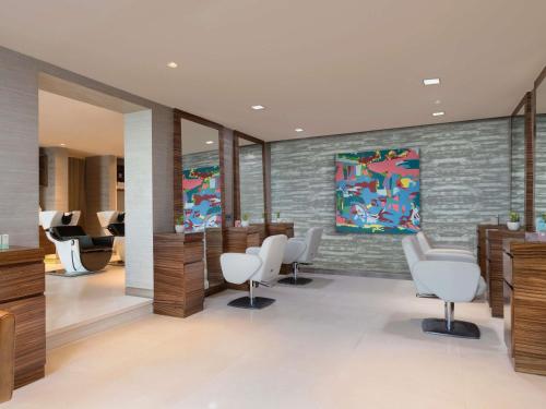 a salon with white chairs and a brick wall at Pullman New Delhi Aerocity in New Delhi