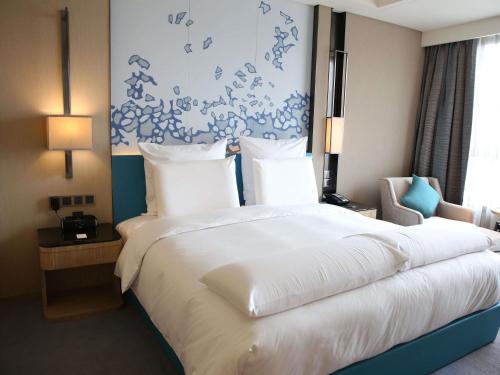 a large white bed in a hotel room at Pullman Taiyuan in Taiyuan