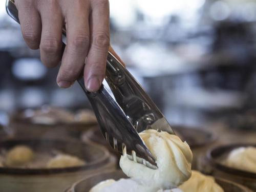 a person is eating food with a fork at Pullman Taiyuan in Taiyuan