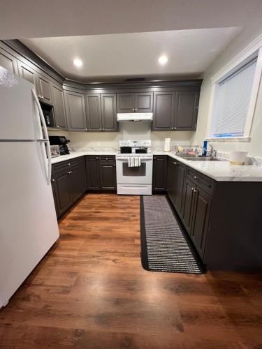 a kitchen with black cabinets and white appliances at Beautiful Entire 2 Bedroom Suite in Nanaimo