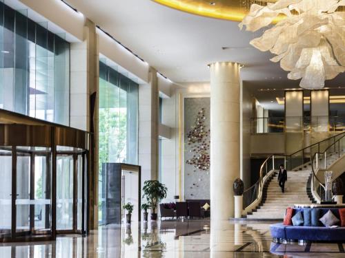 a lobby of a building with a christmas tree at Pullman Changshu Leeman in Changshu