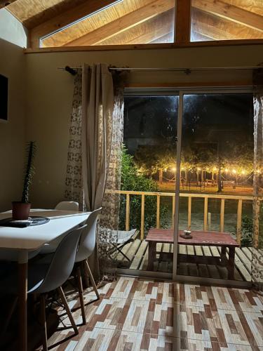 a dining room with a table and a large window at Cabañitas Zelada in Algarrobo