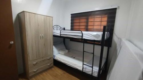 a room with two bunk beds and a cabinet at Danielle's Haven in Naga