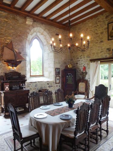une salle à manger avec une table et quelques chaises dans l'établissement Prieure St Pierre de La Luthumiere, à Brix