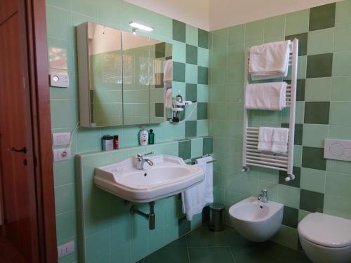 baño verde con lavabo y aseo en IlPoggetto Bed&Breakfast, en Civitanova Marche