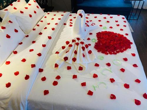a white wedding cake with red hearts on it at James Joyce Coffetel Harbin West High-speed Railway Station Wanda Plaza in Harbin
