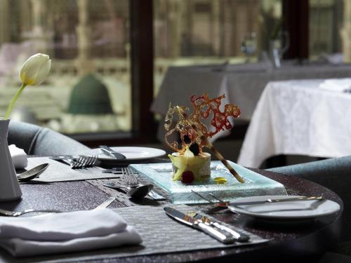a table with plates and utensils on top of it at Pullman Zamzam Madina in Al Madinah