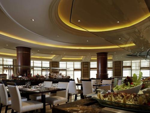 a dining room with tables and chairs in a restaurant at Pullman Zamzam Madina in Al Madinah