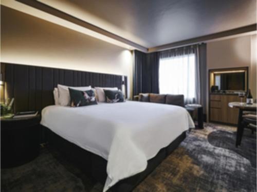 a large white bed in a hotel room at Pullman Melbourne On the Park in Melbourne