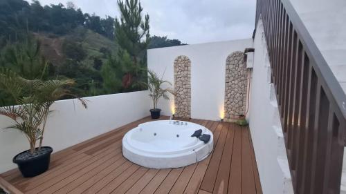 a balcony with a bath tub on a wooden deck at Hanara Bohemian Villa in Bandung