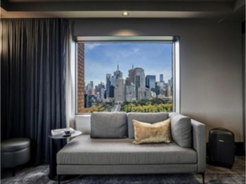 a living room with a couch in front of a window at Pullman Melbourne On the Park in Melbourne