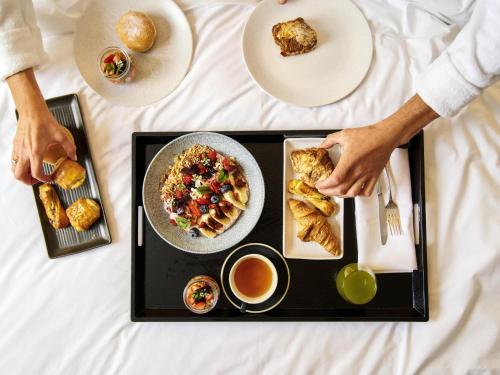 a table with a tray of food and a plate of food at Pullman Melbourne On the Park in Melbourne