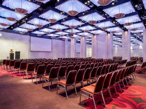 a large room with rows of chairs and a screen at Pullman Melbourne On the Park in Melbourne