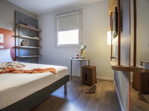 a bedroom with a bed and a window at ibis budget Nice Californie Lenval in Nice