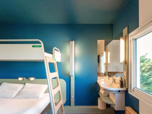 a bedroom with a bunk bed and a sink at ibis budget Mâcon Nord in Mâcon