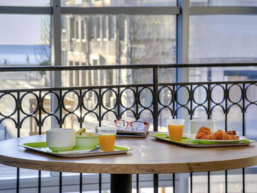 a table with two plates of food and orange juice at ibis budget Nice Californie Lenval in Nice