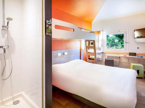 a bedroom with a large white bed and a shower at Ibis Budget Fréjus Capitou in Fréjus