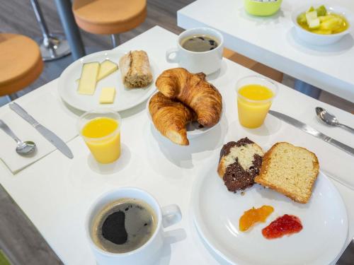 a table topped with plates of breakfast foods and coffee at Ibis Budget Fréjus Capitou in Fréjus