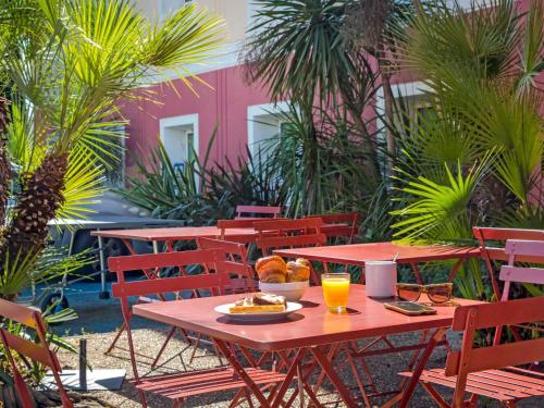 a table with a plate of food and orange juice at Ibis Budget Fréjus Capitou in Fréjus