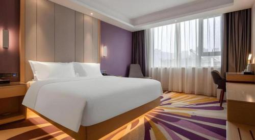 a bedroom with a large white bed and a window at Lavande Hotel Changsha South High-speed Railway Station Xiyingmen in Changsha