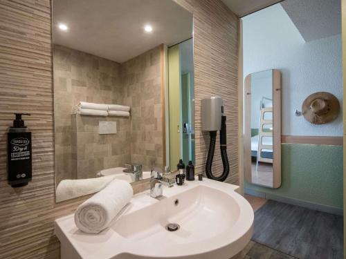 a bathroom with a white sink and a mirror at ibis budget Menton Bord de Mer in Menton