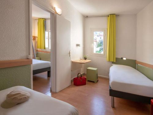 a small room with two beds and a window at ibis budget Menton Bord de Mer in Menton