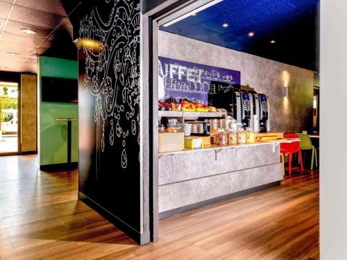 a restaurant with a counter with food on it at ibis budget Menton Bord de Mer in Menton