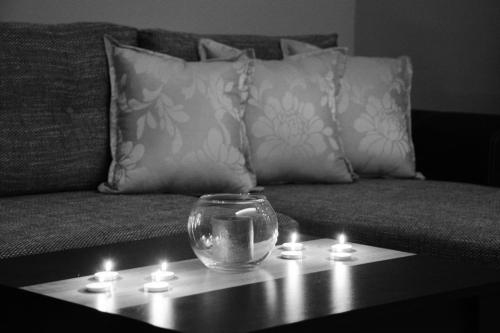 un cuenco de cristal en una mesa con velas en un sofá en Love Apartment en Vrnjačka Banja
