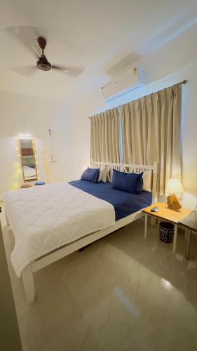 a bedroom with a large bed and a table at ABN Stays in Anjuna
