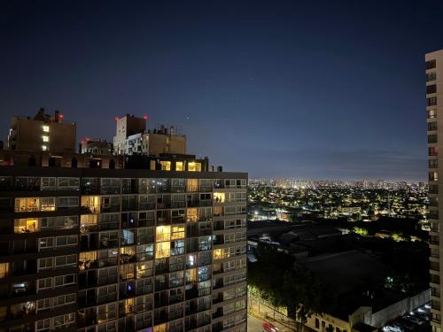 a night view of a building with lights on at Departamento en Maule, cerca Estadio Nacional y metro Ñuble in Santiago