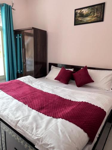 a bed with a red and white blanket on it at Himalayan Wellness Retreat in Narendranagar