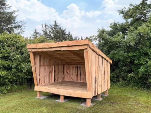 a wooden out house in the grass in a field at 18 person holiday home in Ulfborg-By Traum in Øby