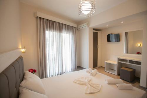 a hotel room with a bed and a large window at Villa Ikaros in Ammoudia