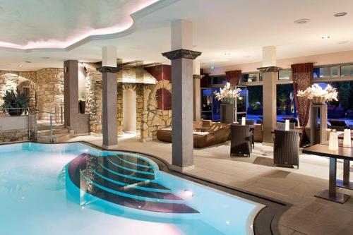 a large swimming pool in a hotel lobby at Parkhotel Heidehof Apartements in Ingolstadt