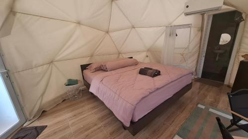 a bedroom with a bed in a tent at Maple Dome Glamping in Bandung