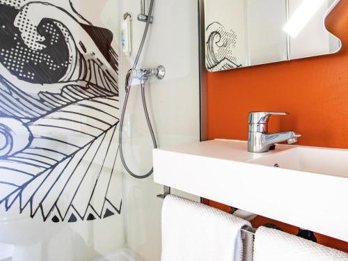 a bathroom with a shower and a sink at Ibis budget Lorient Caudan in Caudan