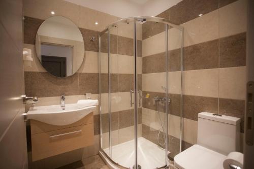 a bathroom with a shower and a toilet and a sink at Villa Ikaros in Ammoudia